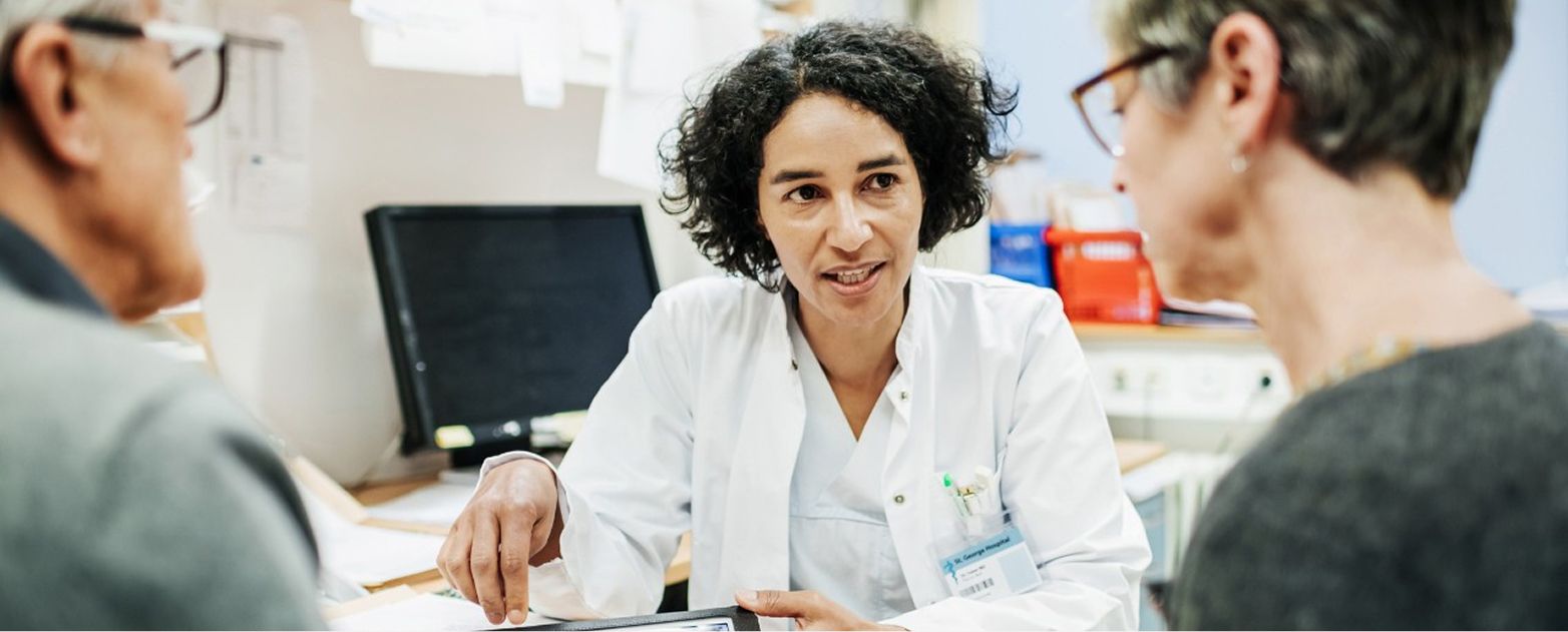 Médica conversando com pacientes em consultório